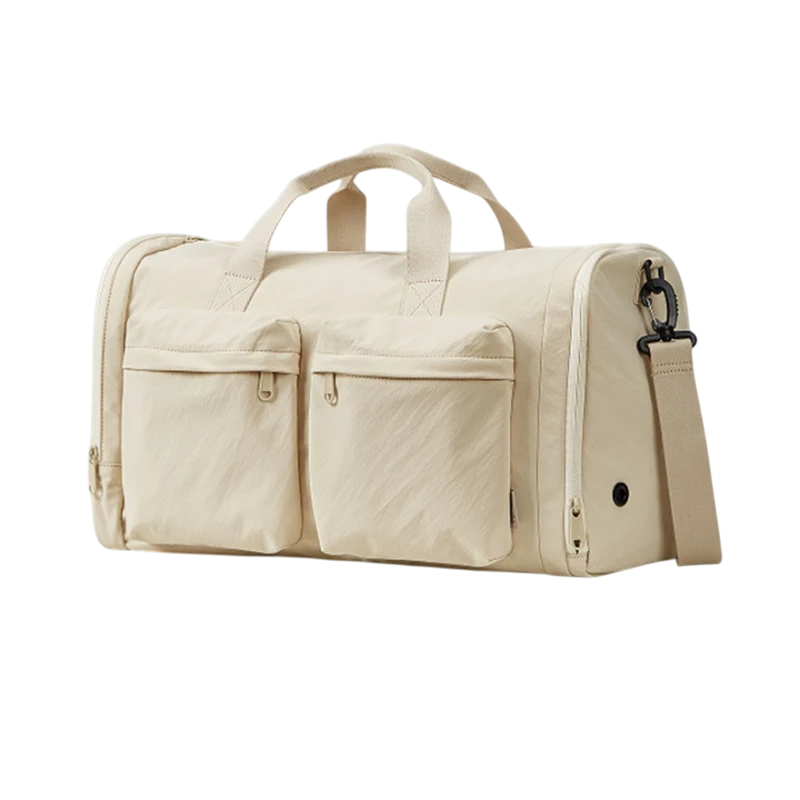 Beige duffel bag with multiple pockets and a shoulder strap on a white background