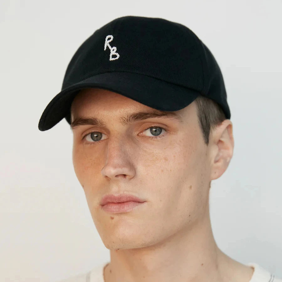 Person wearing a black cap with 'RB' logo on a plain background