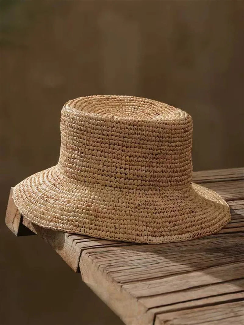 Woven straw hat on a wooden surface with a blurred background
