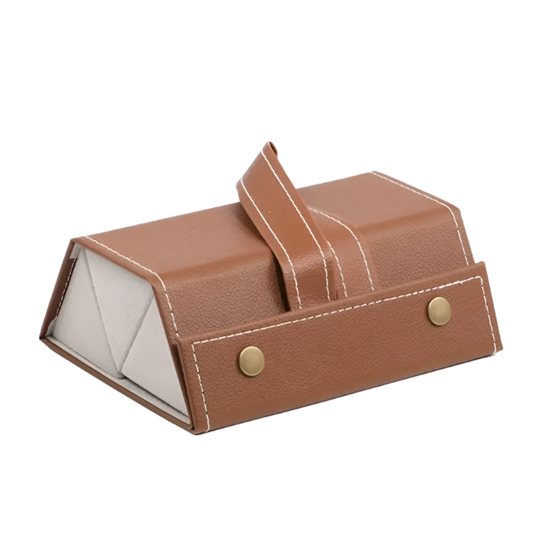 Brown leather jewelry box with gold buttons on a white background