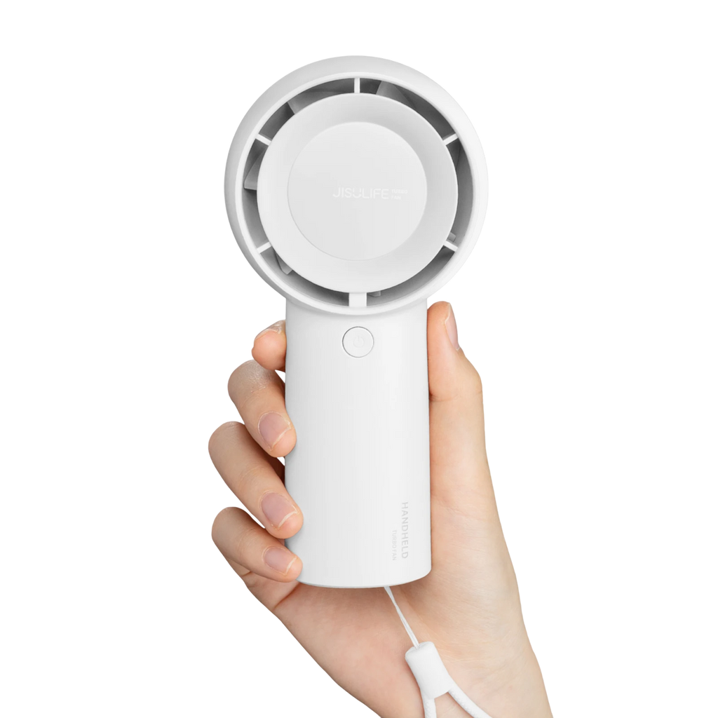 Handheld fan held in a hand against a white background